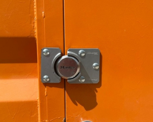 Square 1 Containers A close up of a square orange door with a lock on it.