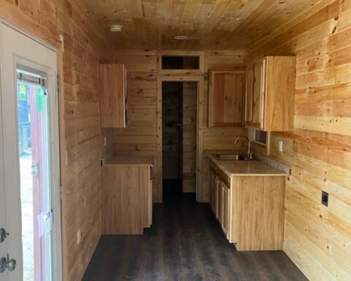 Square 1 Containers The interior of a Square 1 Containers tiny house featuring wood walls.